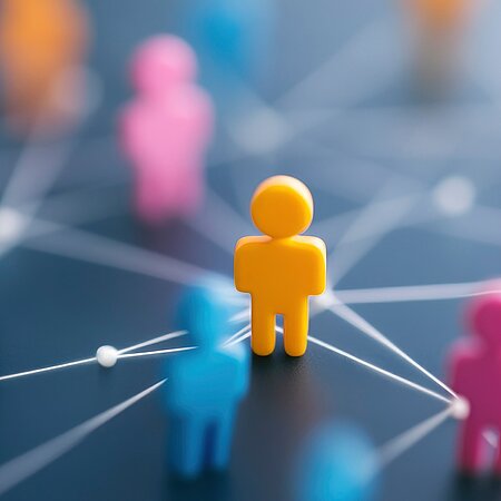 Bunte Spielfiguren auf grauem Hintergrund die über weiße Linien verbunden sind