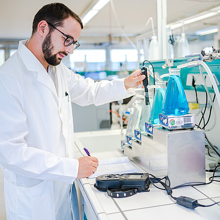 Laborportrait Mitarbeitender an der Rührkesselkasskade mit Messsonde