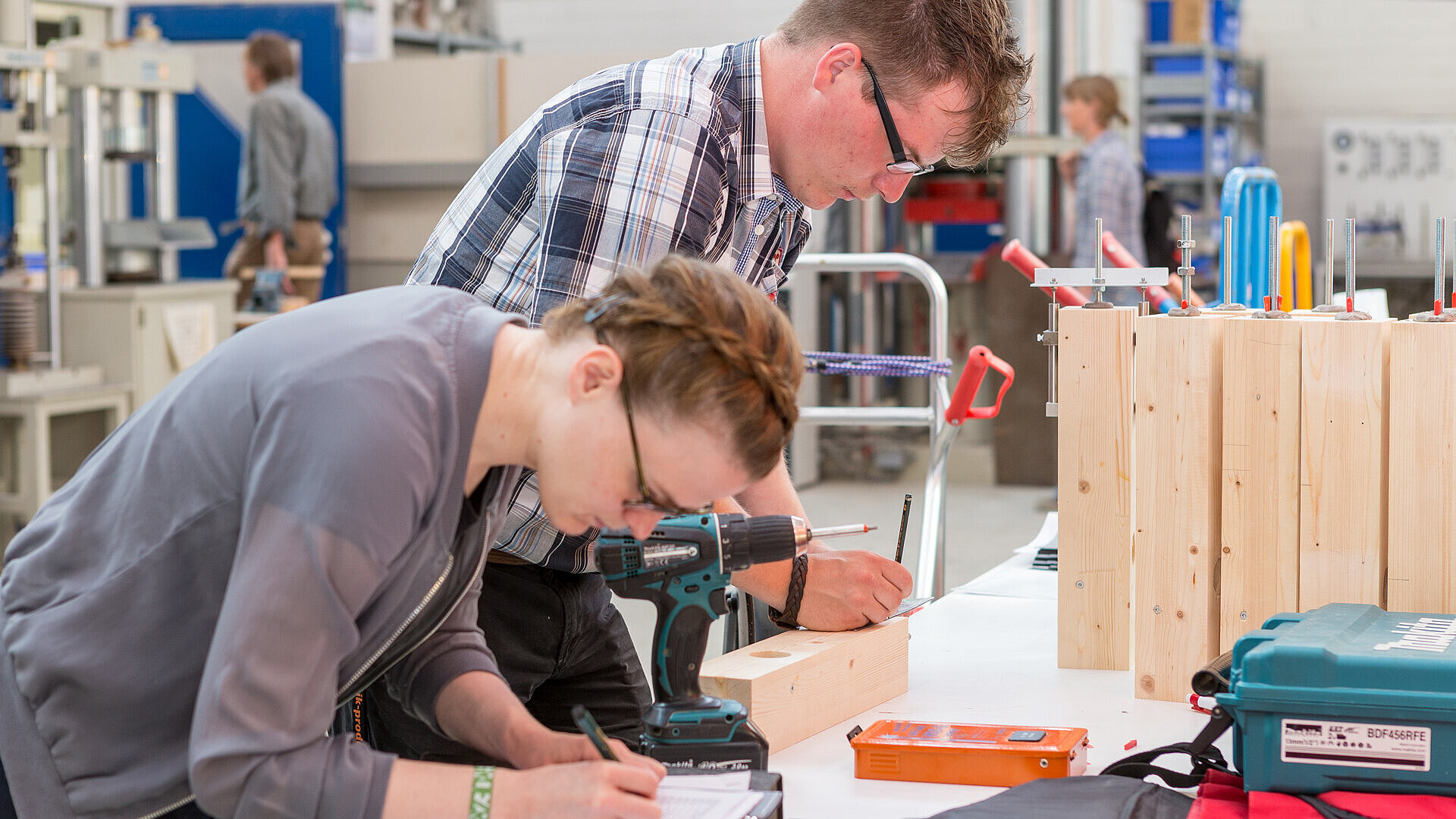 Studentin und Professor arbeiten im Holzbaulabor
