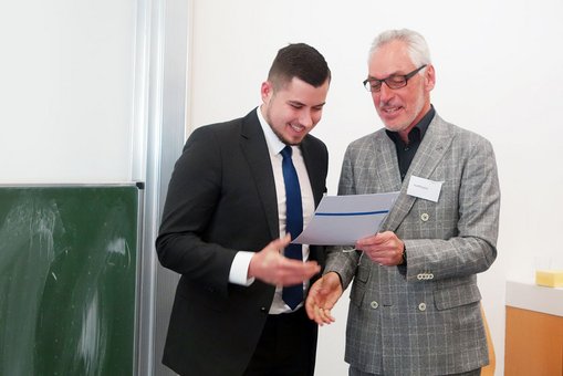 Der 1. Vorsitzende der Betriebswirtschaftlichen Gesellschaft Wiesbaden e.V., Klaus Hoffmann überreicht den Preis an Janis Bothe 