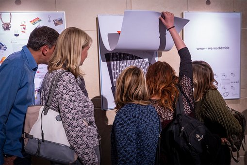 Besucher der Veranstaltung begutachten den neuen Hochschulkalender