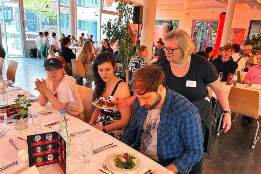 Eine Frau in Kellnerschürze serviert Essen.
