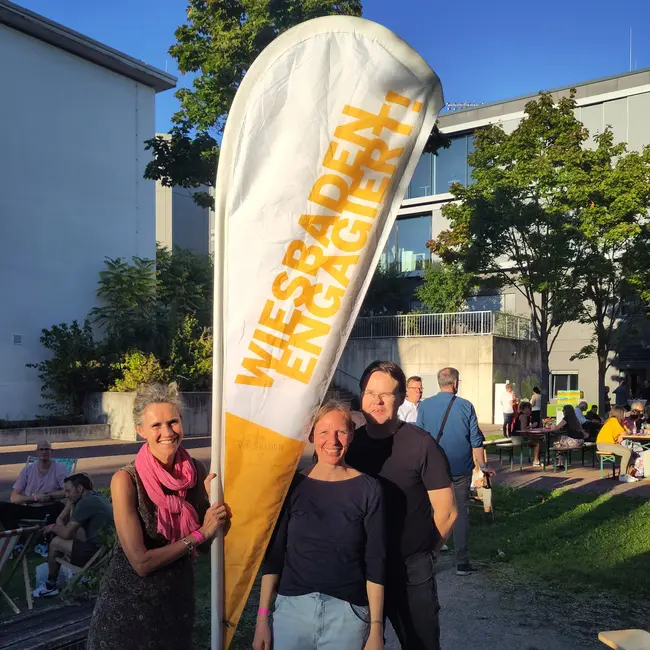 HSRM-Mitarbeitende vor einem Wiesbaden Engagiert-Banner