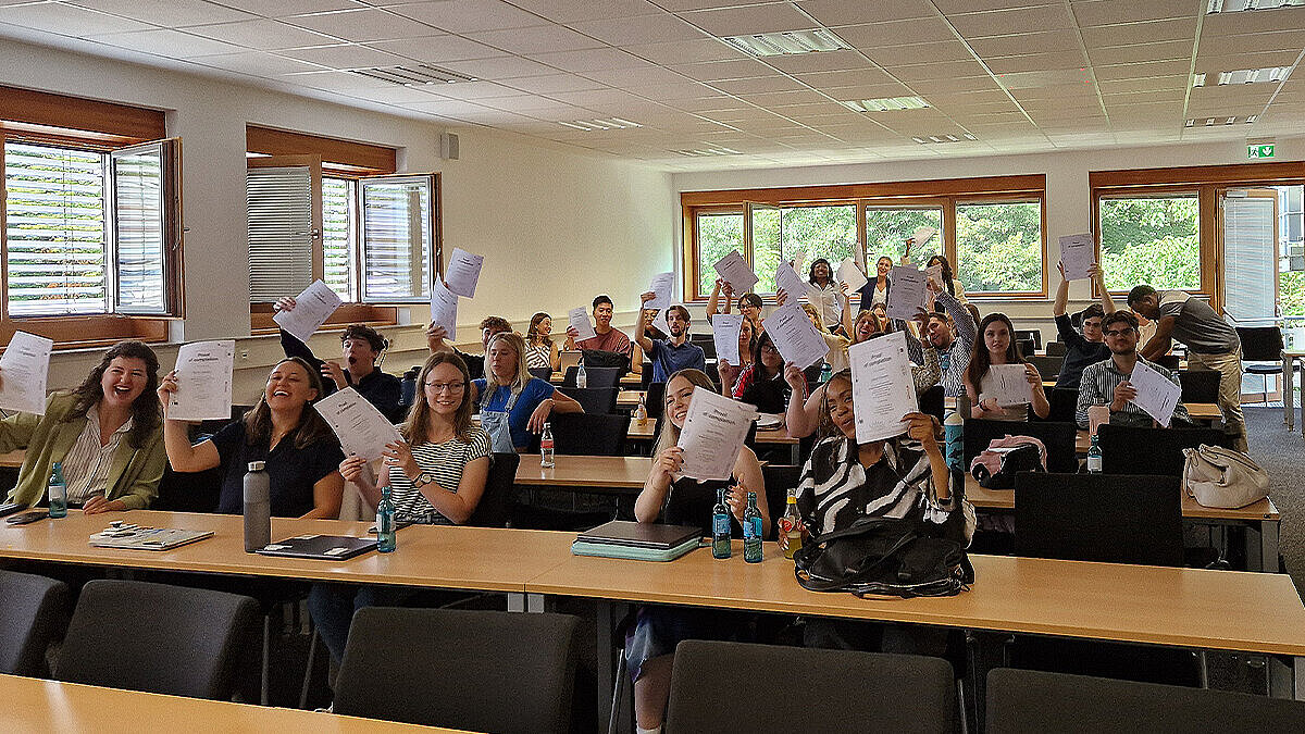 Gruppenfoto auf dem die Teilnehmenden der Summer School ihre Zertifikate hochhalten. 