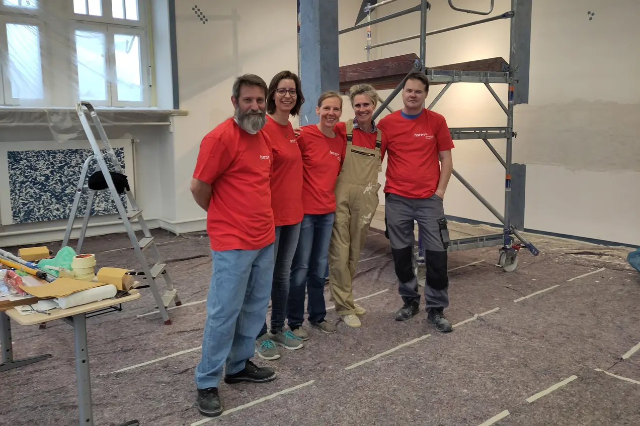 Mitarbeitende in roten HSRM-T-Shirts in der Bibliothek