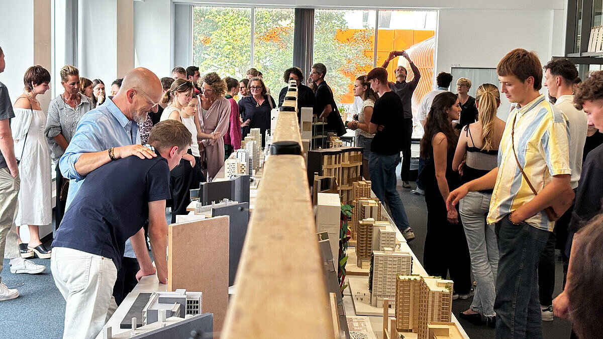 Besucher:innen der Vernissage im HSRM-Stadtlabor bestaunen die Exponate