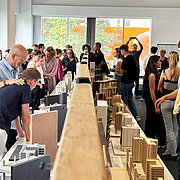 Besucher:innen der Vernissage im HSRM-Stadtlabor bestaunen die Exponate
