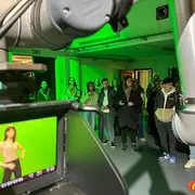 Blick durch den Arm eines Kameraroboters auf Schüler:innen