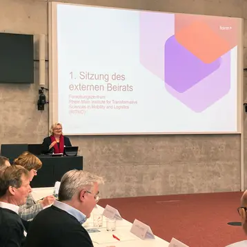 President Prof. Dr. Eva Waller stands in front of a screen and gives a welcoming speech at the first meeting of the external advisory board of the RITMO Research Center.