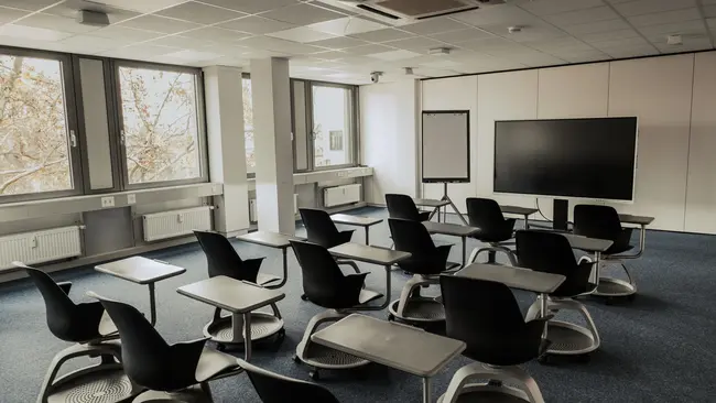 Raum mit Stühlen, Whiteboard und Flipchart
