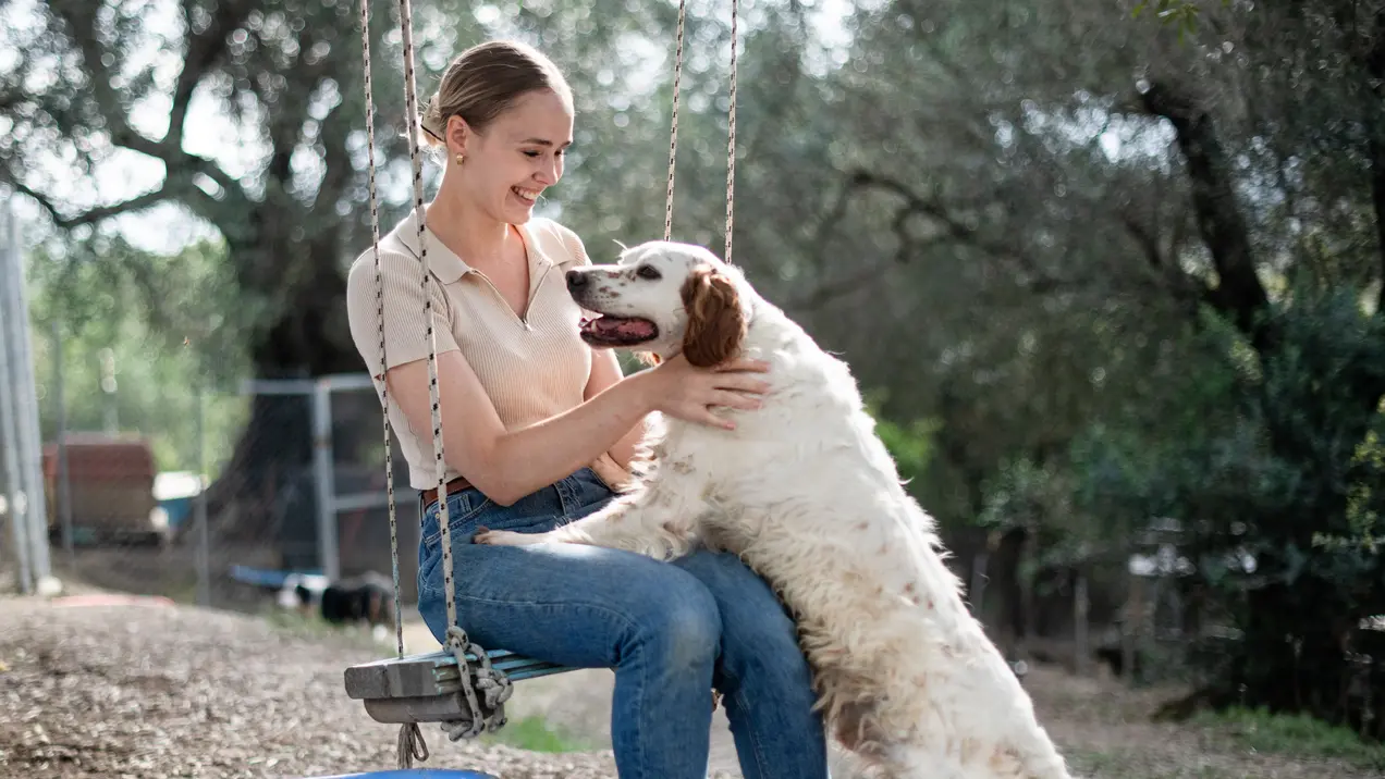 Zerina Kaps auf einer Schaukel, Hund angelehnt