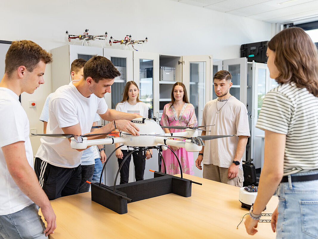 Studierende am Fachbereich Ingenieurwissenschaften Studierende stehen um einen tisch und begutachten eine Drohne