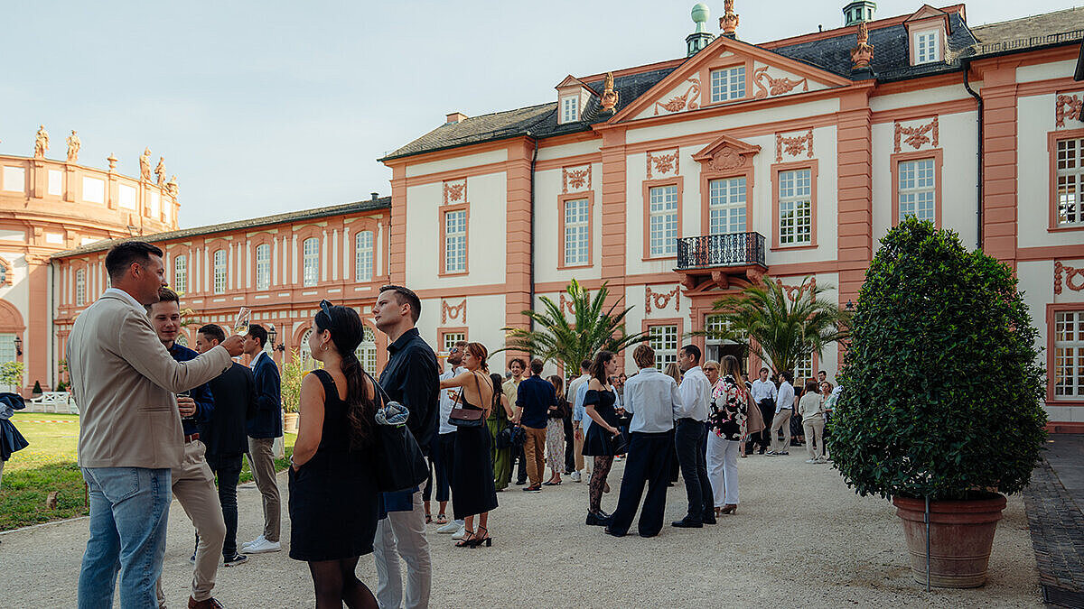 Personen stehen vor dem Schloss Biebrich