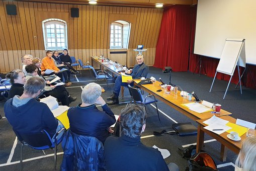 Die Mitglieder der Jury sitzen zusammen und besprechen die vorgestellten Entwürfe