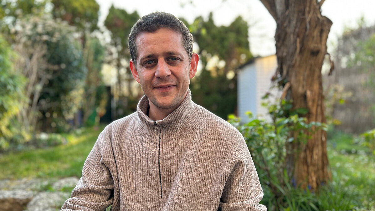 David Ailabouni sitzt in einem Garten