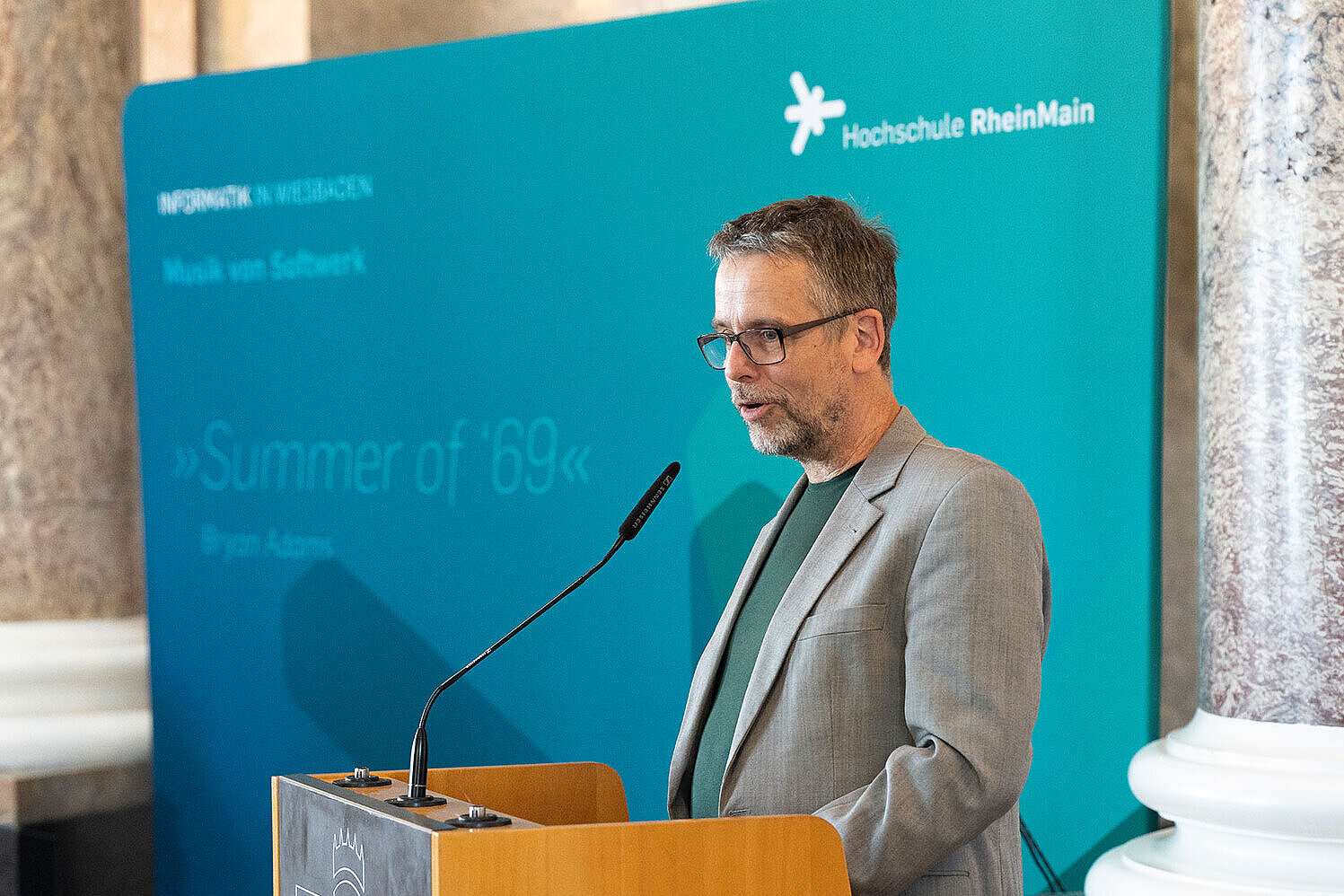 Prodekan Prof. Dr. Martin Gergeleit steht während seines Grußworts am Rednerpult und spricht ins Mirkofon.