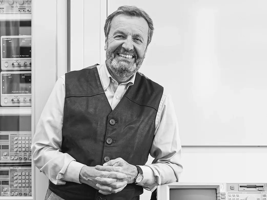 Ehemaliger der Hochschule RheinMain, Wilfried Kiegler Ehemaliger im Rentenalter lehnt an technischem Gerät seiner Studienzeit