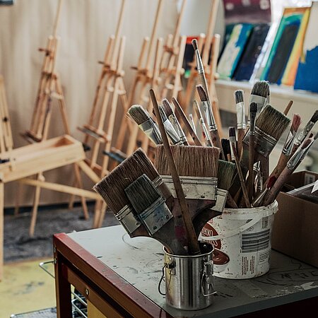 Atelier Pinsel mit Staffeleien im Hintergrund