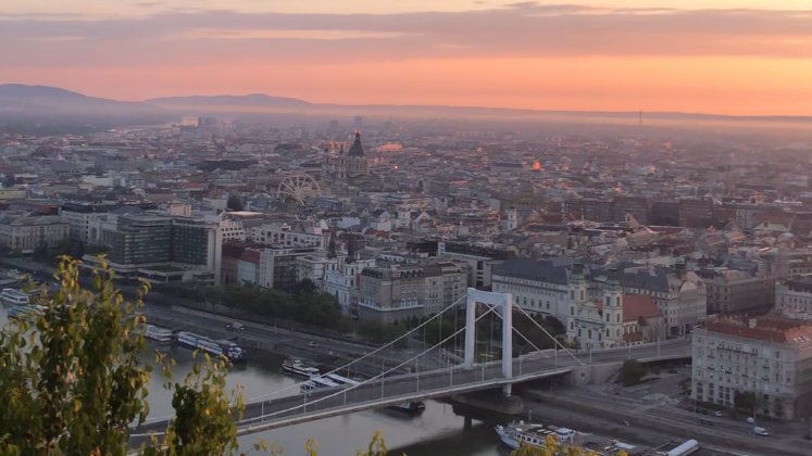 Man kann die Aussicht auf einen Fluss und Stadt vom Gellért Hill sehen. Die Sonne ist am aufgehen