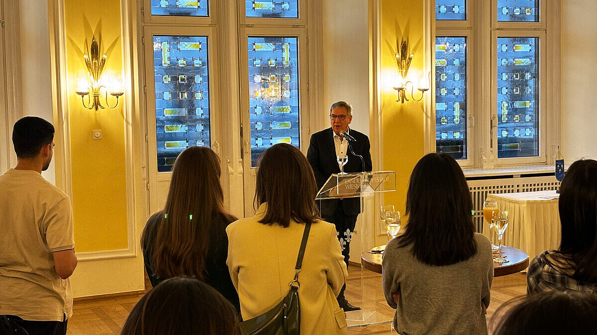 Oberbürgermeister Gert-Uwe Mende begrüßt die Studierenden in Wiesbaden. 