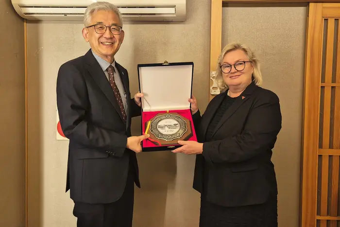 Der Präsident der Myongji University Yun-Soo Lim überreicht Prof. Dr. Eva Waller ein Gastgeschenk.
