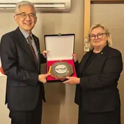 Der Präsident der Myongji University Yun-Soo Lim überreicht Prof. Dr. Eva Waller ein Gastgeschenk.