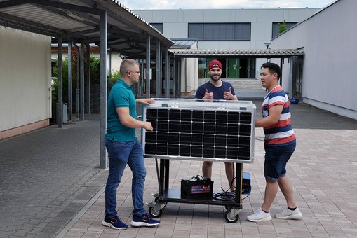 Kevin Weilbacher, Benjamin Rapp, and Andreas Nguyen with their mobile solar charging station.