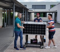 Kevin Weilbacher, Benjamin Rapp, and Andreas Nguyen with their mobile solar charging station.