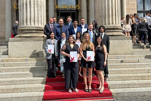 Gruppenfoto der Absolvent:innen des Studiengangs International Management (M. A.) vor dem Kurhaus Wiebaden