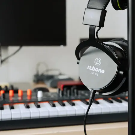 Kopfhörer mit Keyboardmixer im Hintergrund
