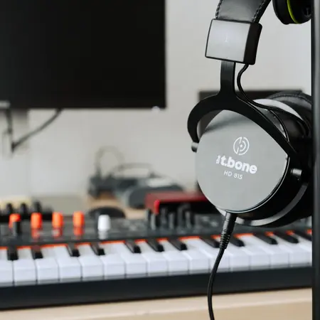 Kopfhörer mit Keyboardmixer im Hintergrund