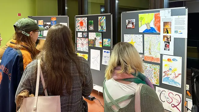 Gäste des Länderabends Ukraine schauen sich die Exponate einer Ausstellung an.