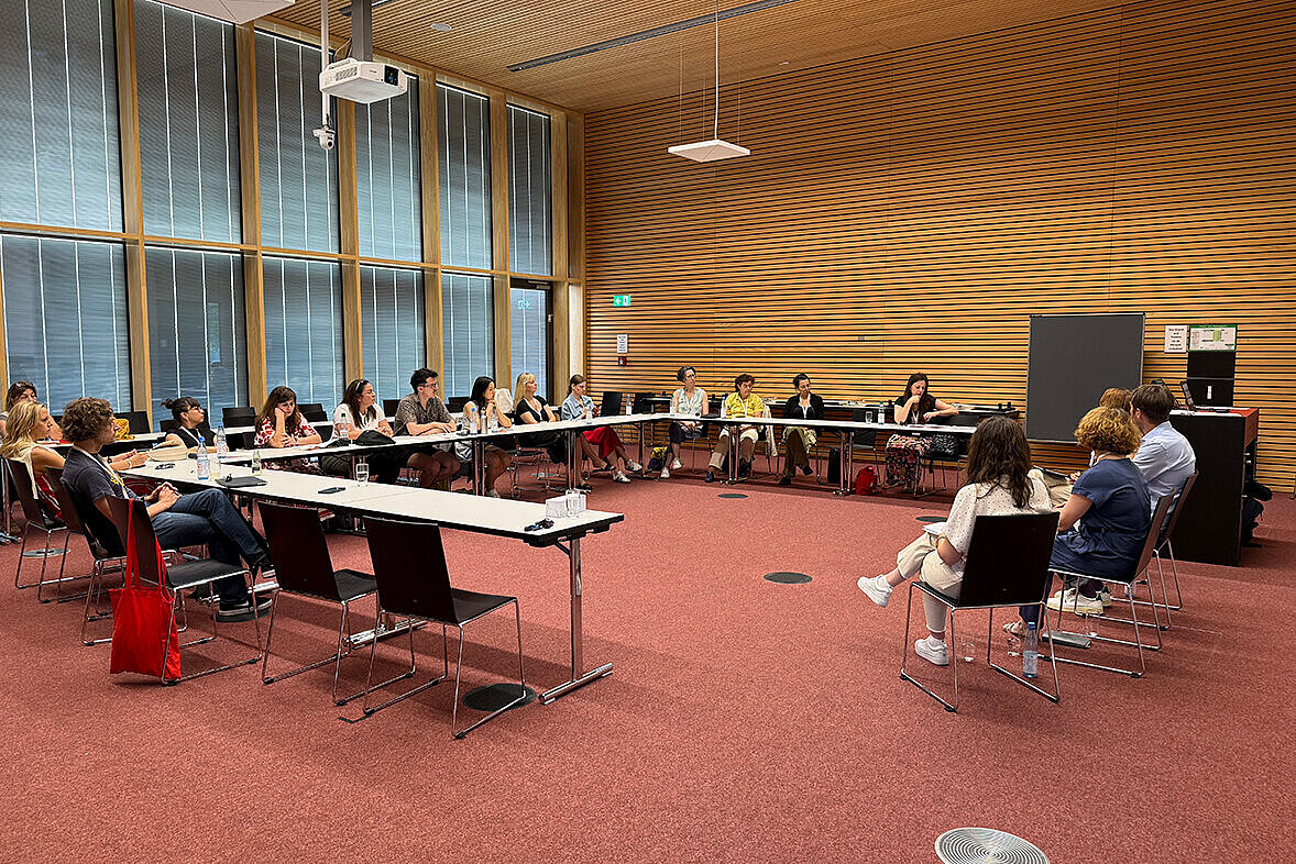 Die Teilnehmer:innen der International Staff Week sitzen in einem Konferenzraum zusammen. 