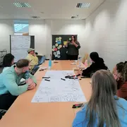 Teilnehmende vom Vernetzungskongress sitzen gemeinsam an einem Tisch