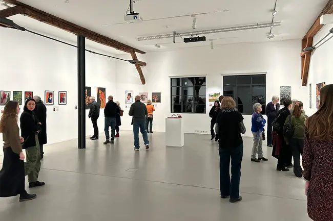 Besucher:innen der Ausstellung Art Remake laufen durch den Raum und betrachten die Werke.