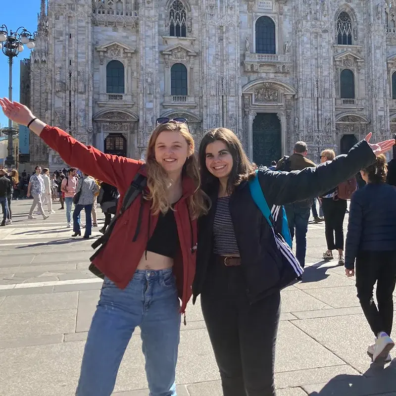 Zwei jungen Frauen posieren vor einem alten Gebäude für ein Foto