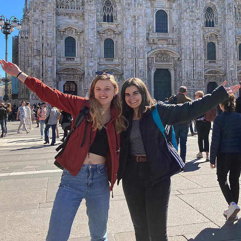 Zwei jungen Frauen posieren vor einem alten Gebäude für ein Foto