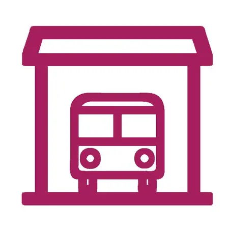 Ein einfaches Icon eines Busses, der in eine Haltestelle einfahren möchte. Die Haltestelle hat ein schräges Dach und umrahmt den Bus. Das Symbol steht für öffentliche Verkehrsmittel und Haltestellen.