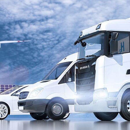 E-Lkw, E-Transporter und E-Pkw mit Windrädern und Photovoltaik im Hintergrund